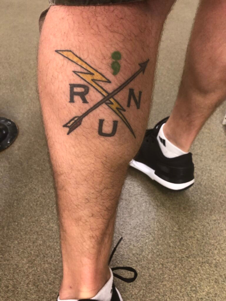 Reflecting on SIR - Still I Run tattoo on man's leg