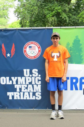 Luke Davis standing in front of the U.S. Olympic Team Trials banner.