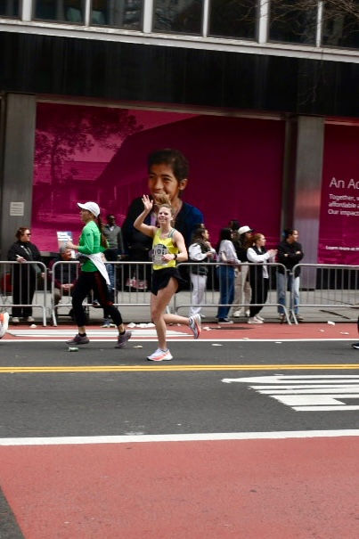 a person waving while running a race as part of Team Still I Run