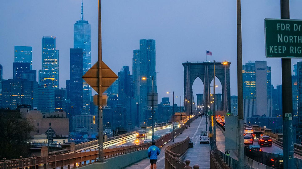 A person running across a bridge during sunset.