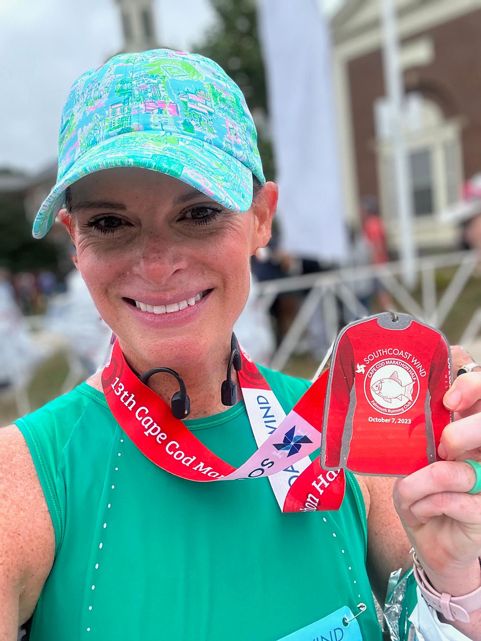 a woman holding up a race medal