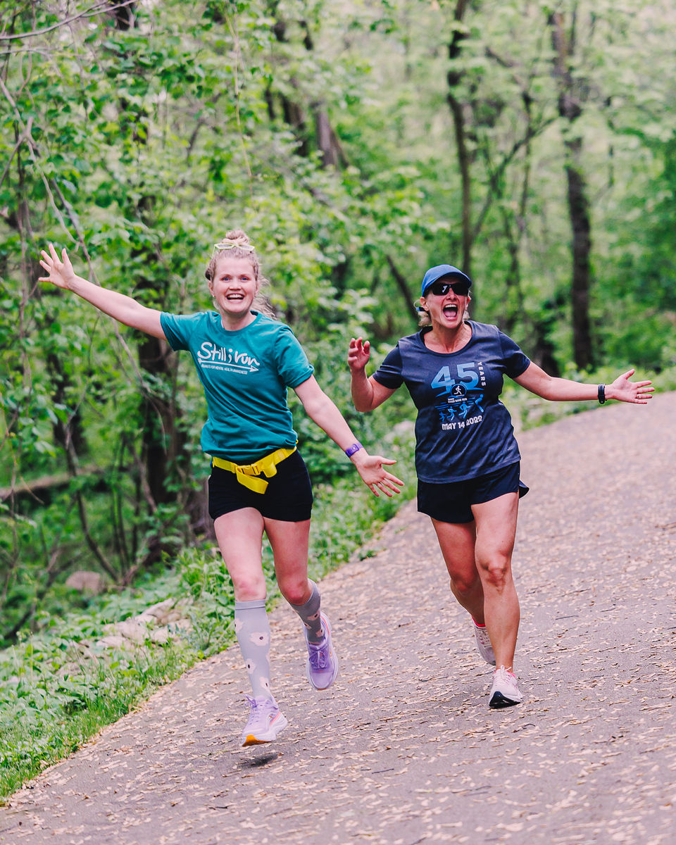 two runners jumping and smiling