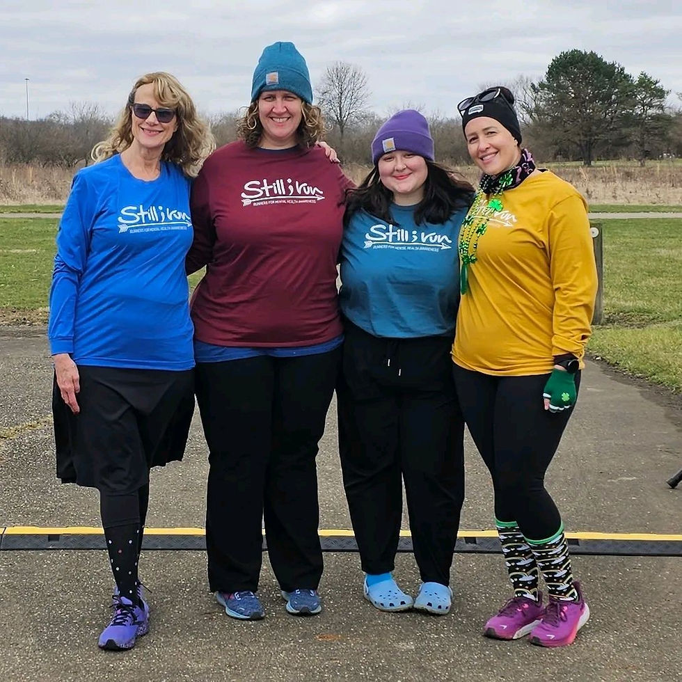 A group of runners posing in Still I Run gear