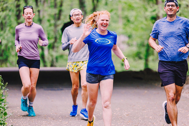 A group of people running with one woman waving