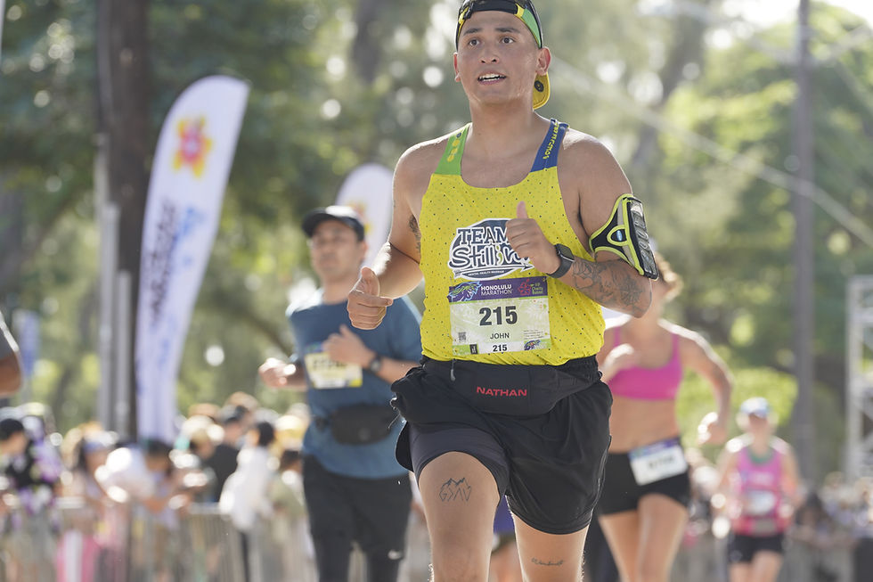 a person running the Honolulu marathon wearing a Team Still I Run race jersey