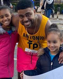 A man posing with his two daughters.