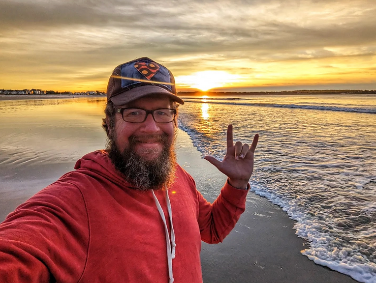 a man standing on the beach taking a selfie