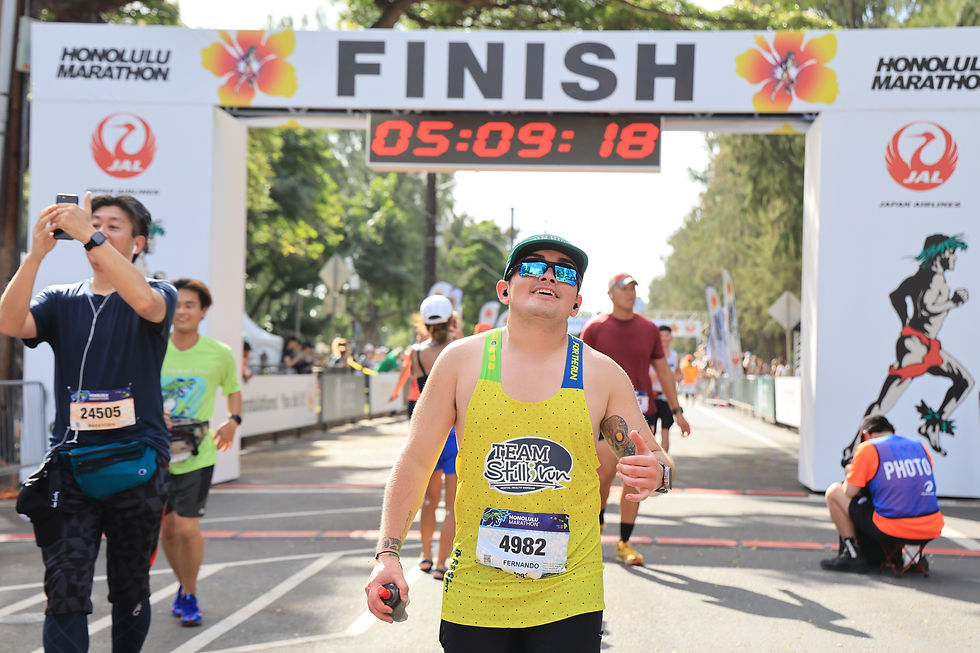 a man crossing the finish line at the Honolulu Marathon