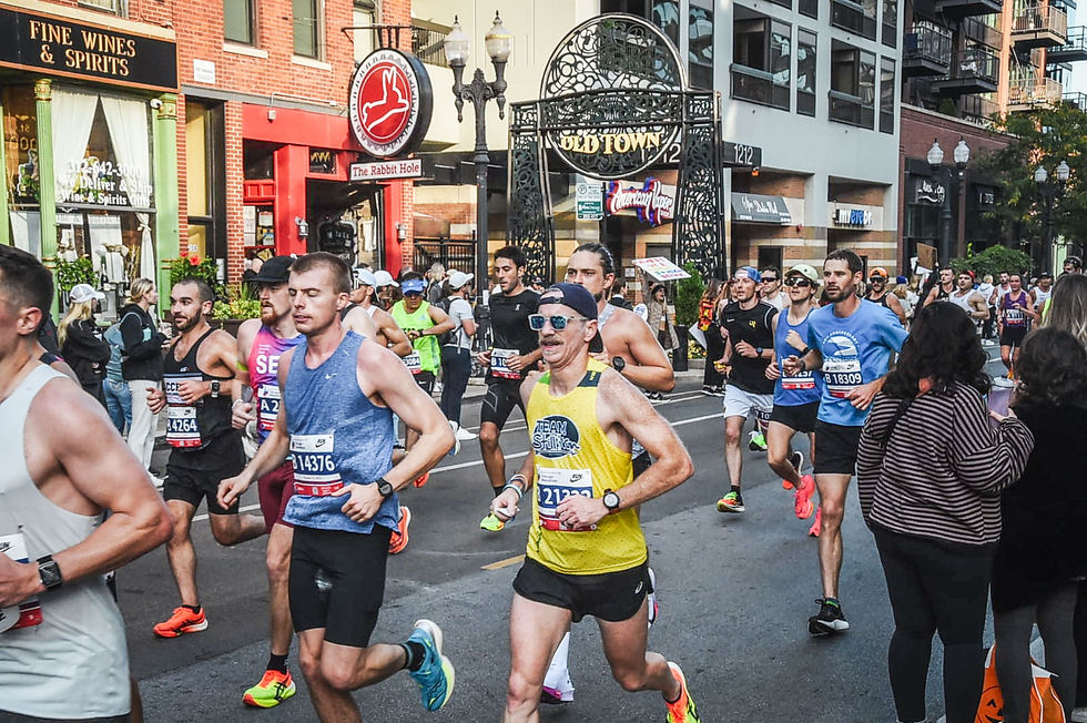 A runner wearing a yellow Team Still I Run running singlet in the Chicago Marathon. 